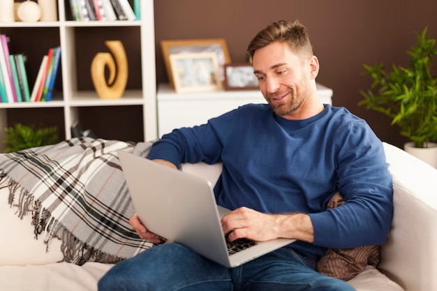 Free photo handsome man with contemporary laptop at home