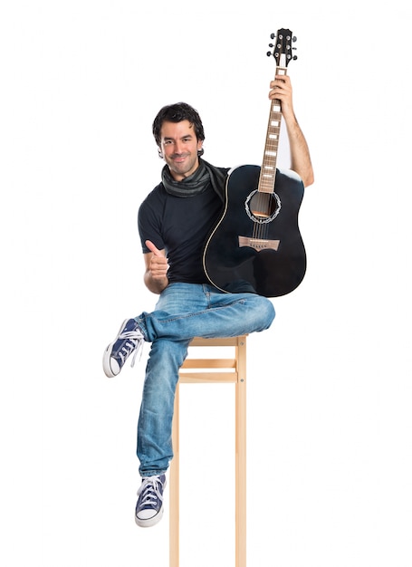 Handsome man with guitar over white background