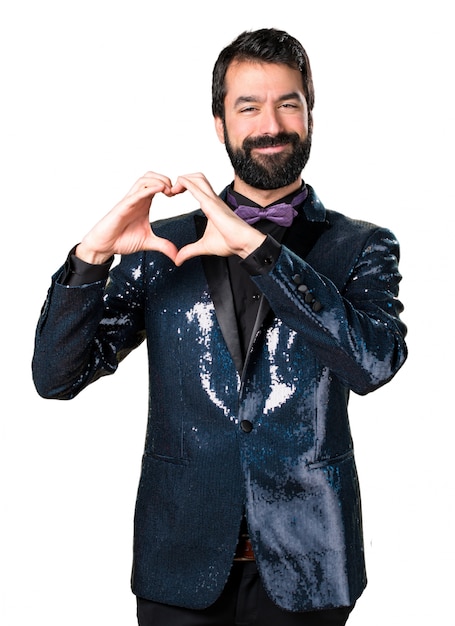 Handsome man with sequin jacket making a heart with his hands