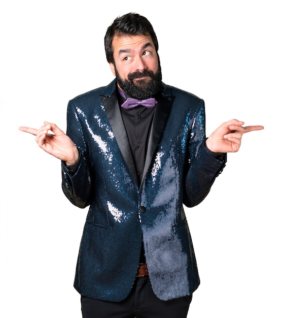 Free Photo handsome man with sequin jacket pointing to the laterals having doubts