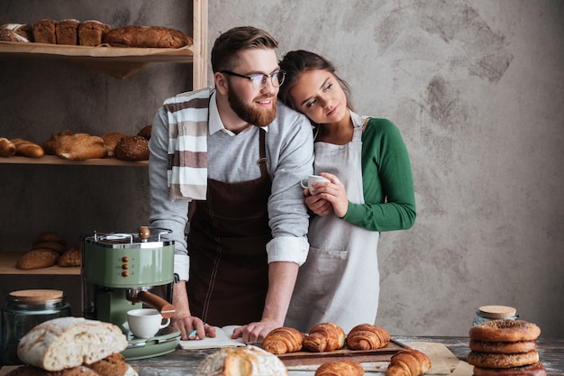 Free photo handsome man and woman standing near table and looking window