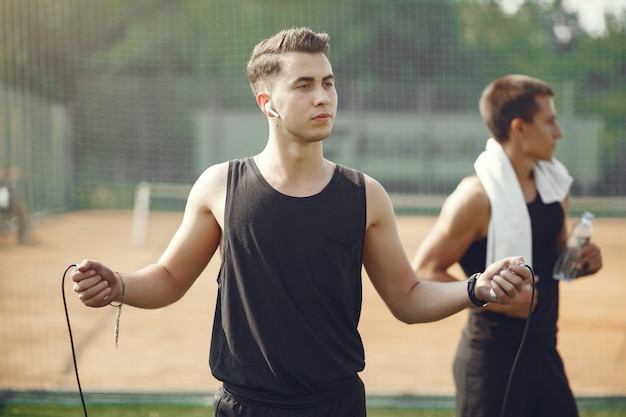 Handsome men in a sports clothes standing in a park