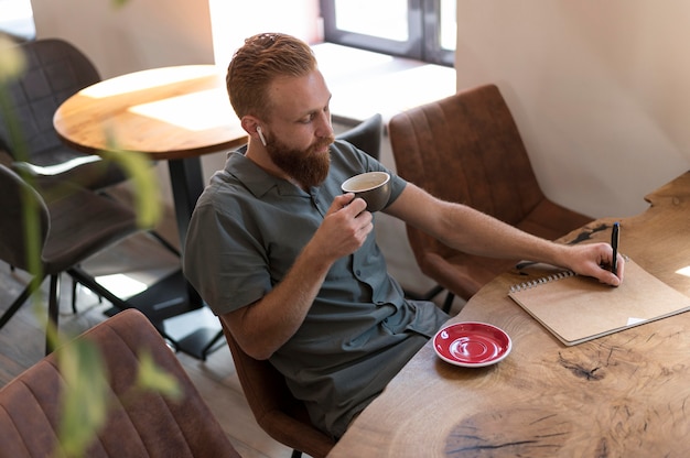 Free Photo handsome modern man holding a cup of coffee