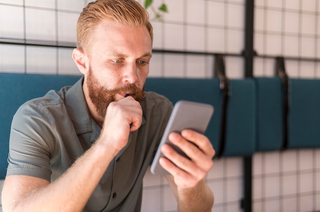 Free photo handsome modern man looking at his phone