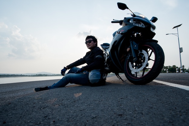 Free photo handsome motorbiker with helmet in hands of motorcycle