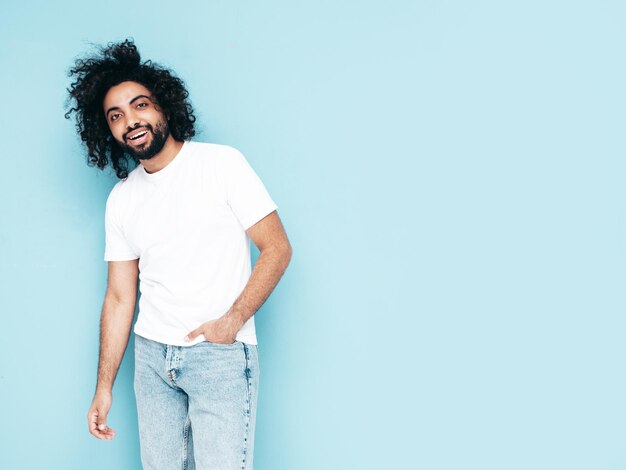 Free Photo handsome smiling hipster man posing in studio