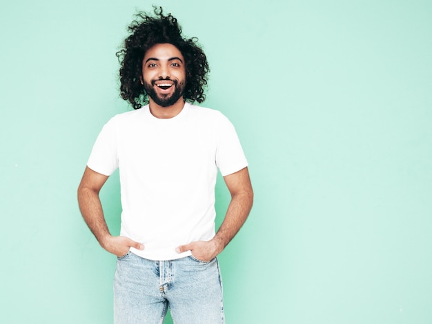 Free Photo handsome smiling hipster man posing in studio