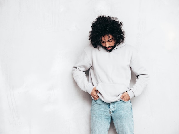 Free photo handsome smiling hipster man posing in studio