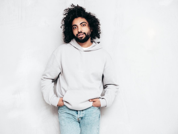 Free photo handsome smiling hipster man posing in studio