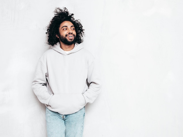 Free photo handsome smiling hipster man posing in studio