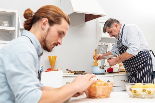 Free photo handsome son and father cooking