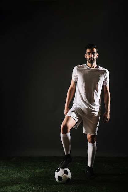 Free photo handsome sportsman stepping on ball