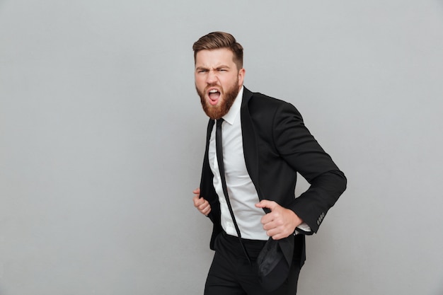 Free photo handsome stylish businessman in suit posing while standing