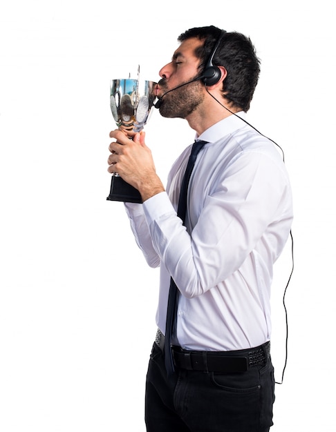 Handsome telemarketer man holding a trophy