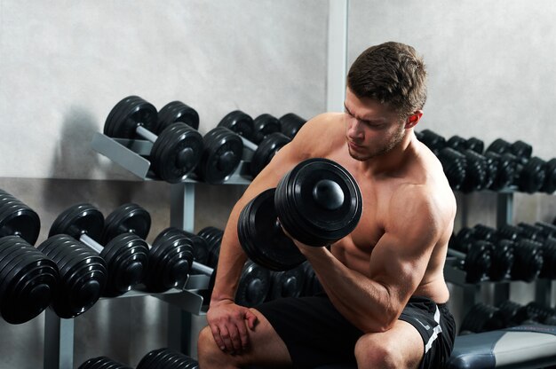 Handsome young athlete working out at the gym