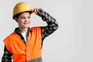 Free photo handsome young boy posing with hard hat