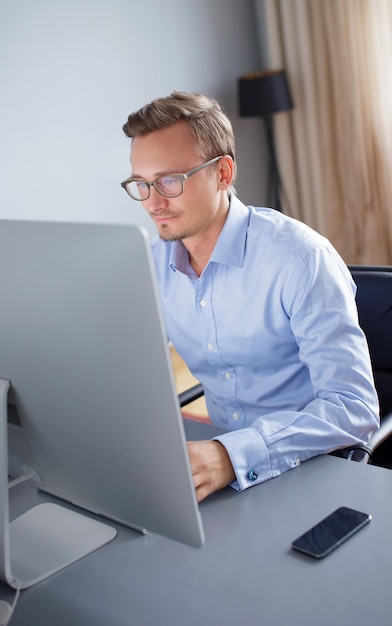 Free photo handsome young business man working with computer in office.