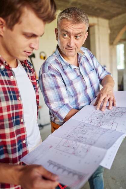 Free Photo handsome young carpenter working with an experienced man