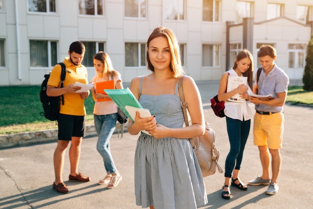  Handsome young girl with red velvet backpack holding books