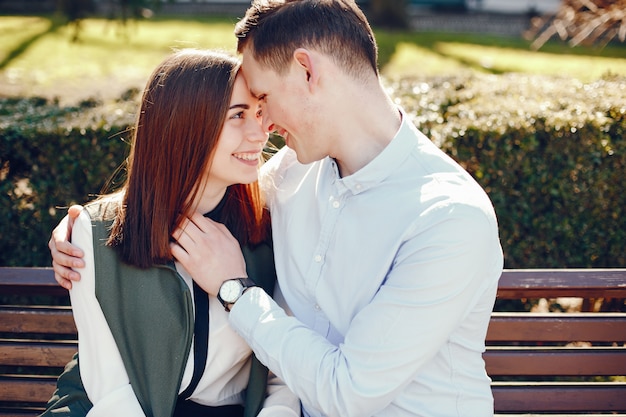 handsome young guy in a blue shirt sitting in a sunny summer city along with her cute girl