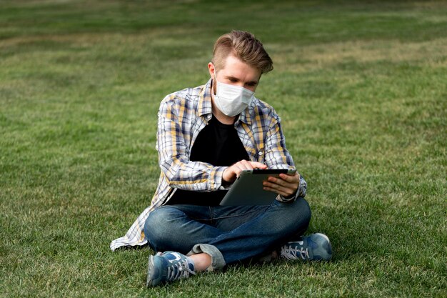 Handsome young man browsing tablet outdoors