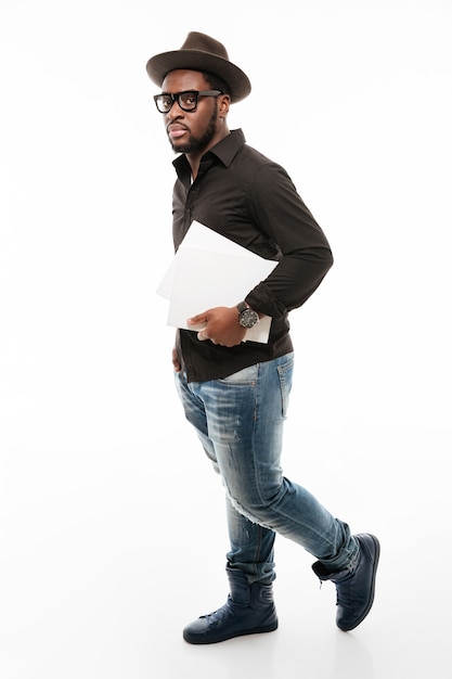 Handsome young man dressed in shirt wearing hat and holding papers