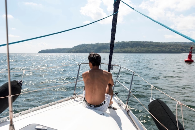 Free photo handsome young man enjoying time on boat