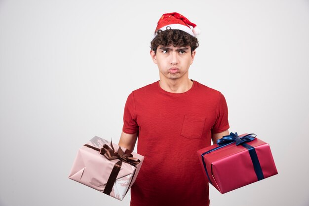 Handsome young man feeling bored with gift boxes.