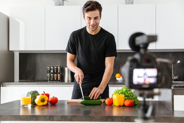 Handsome young man filming his video blog episode