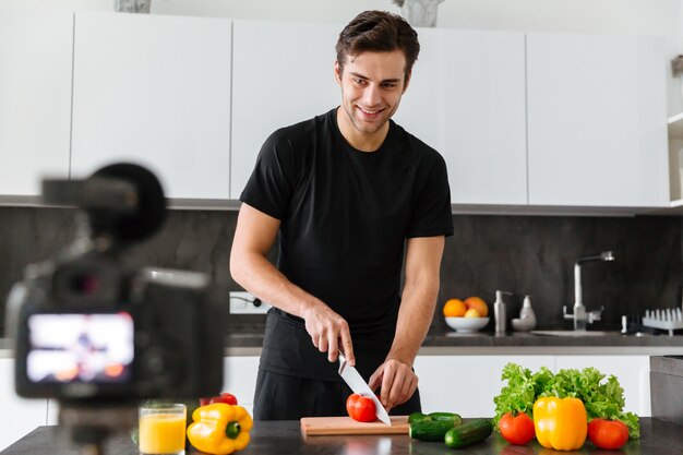 Free photo handsome young man filming his video blog episode