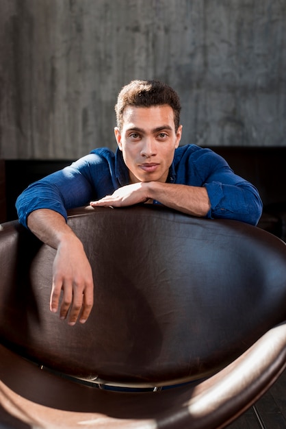 Free photo handsome young man leaning behind the edge of sofa