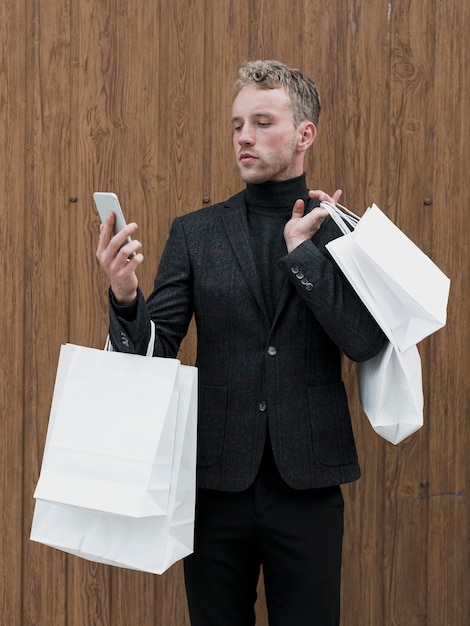 Free photo handsome young man looking at smartphone