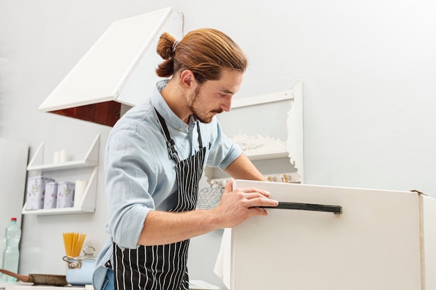 Free photo handsome young man opening a fridge