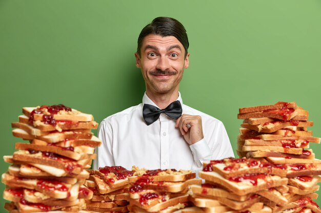 Handsome young man surrounded by peanut butter jellly sandwiches