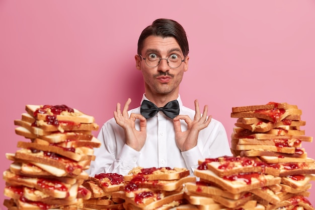 Free Photo handsome young man surrounded by peanut butter jellly sandwiches