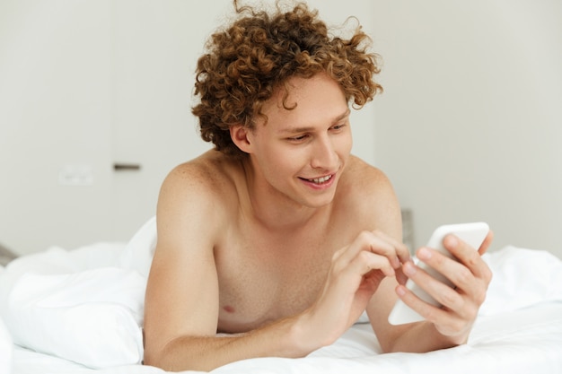 Free Photo handsome young man typing a message on mobile phone