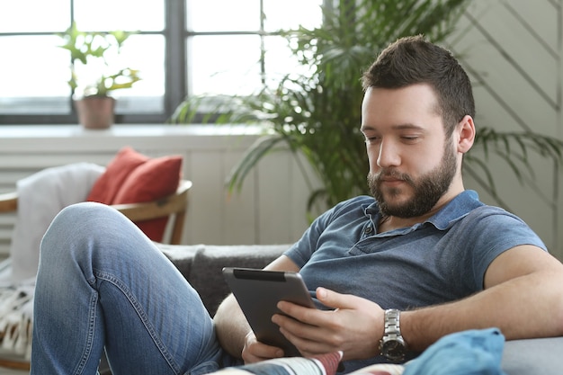 Handsome young man using digital tablet or ebook