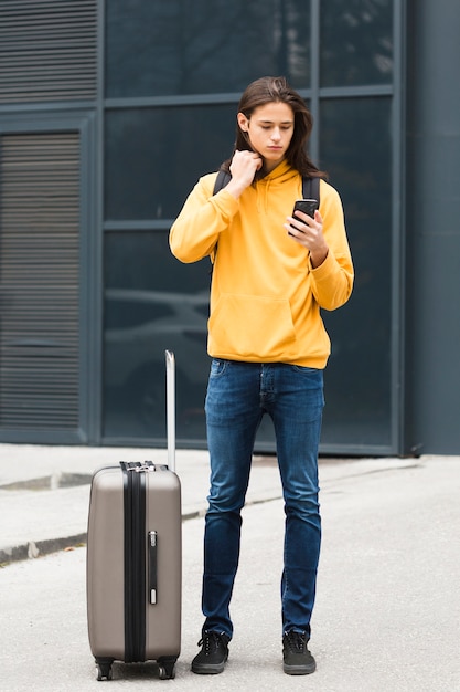 Free photo handsome young traveler checking his phone