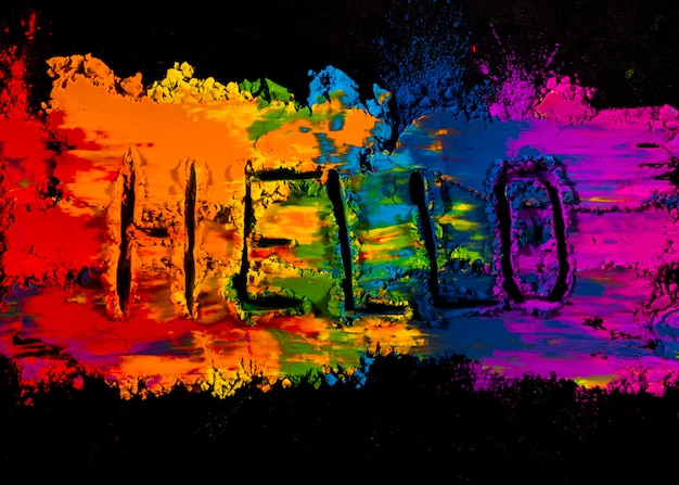 Free photo handwritten hello text on colorful holi powder color against black background