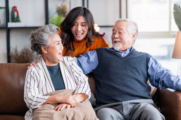 Happiness asian family candid of daughter hug grandparent mother farther senior elder cozy relax on sofa couch surprise visiting in living room at hometogether hug cheerful asian family at home