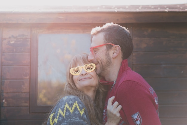 Free photo happy adult couple with heart glasses