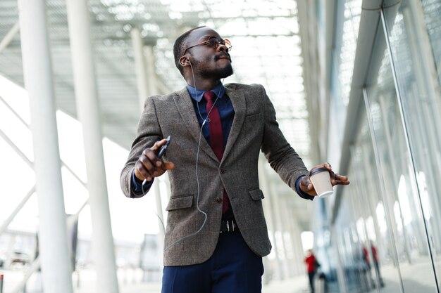 Happy African American business man dances while he listens to the music