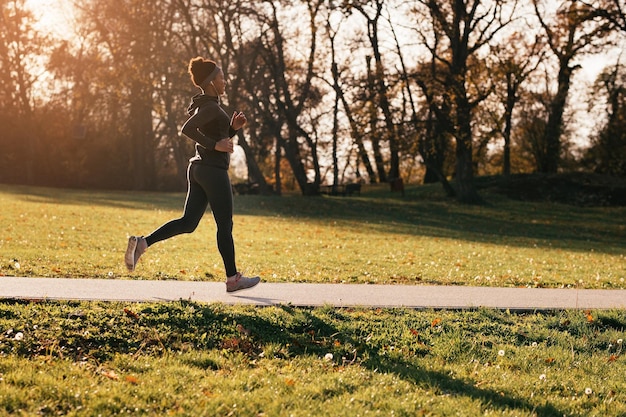 Free photo happy african american female athlete running in the park copy space