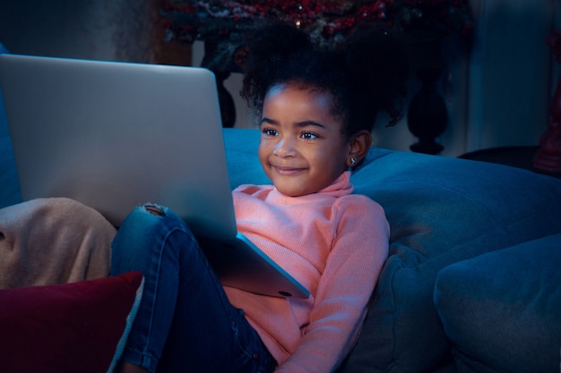 Free photo happy african-american little girl during video call with laptop