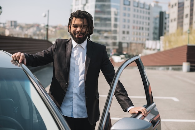 Happy afroamerican man leaving car