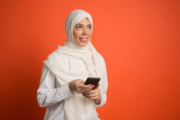 Happy arab woman in hijab with mobile phone.