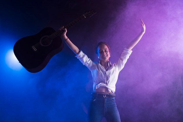 Free Photo happy artist on stage holding the guitar