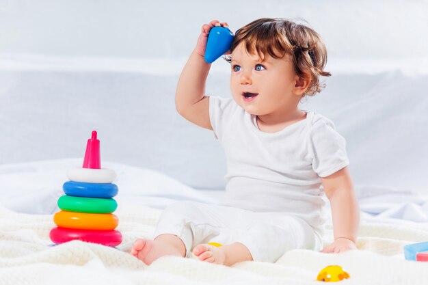 Happy baby boy sitting with toy