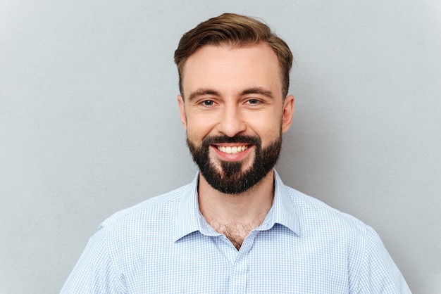 Happy bearded man in business clothes looking at the camera