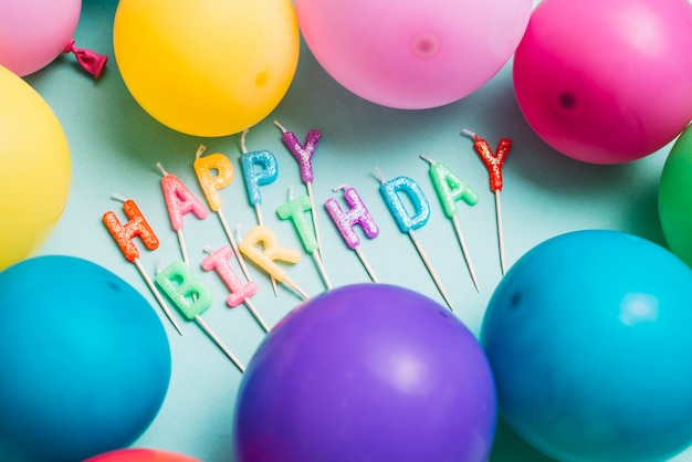 Free Photo happy birthday candles stick surrounded with colorful balloons